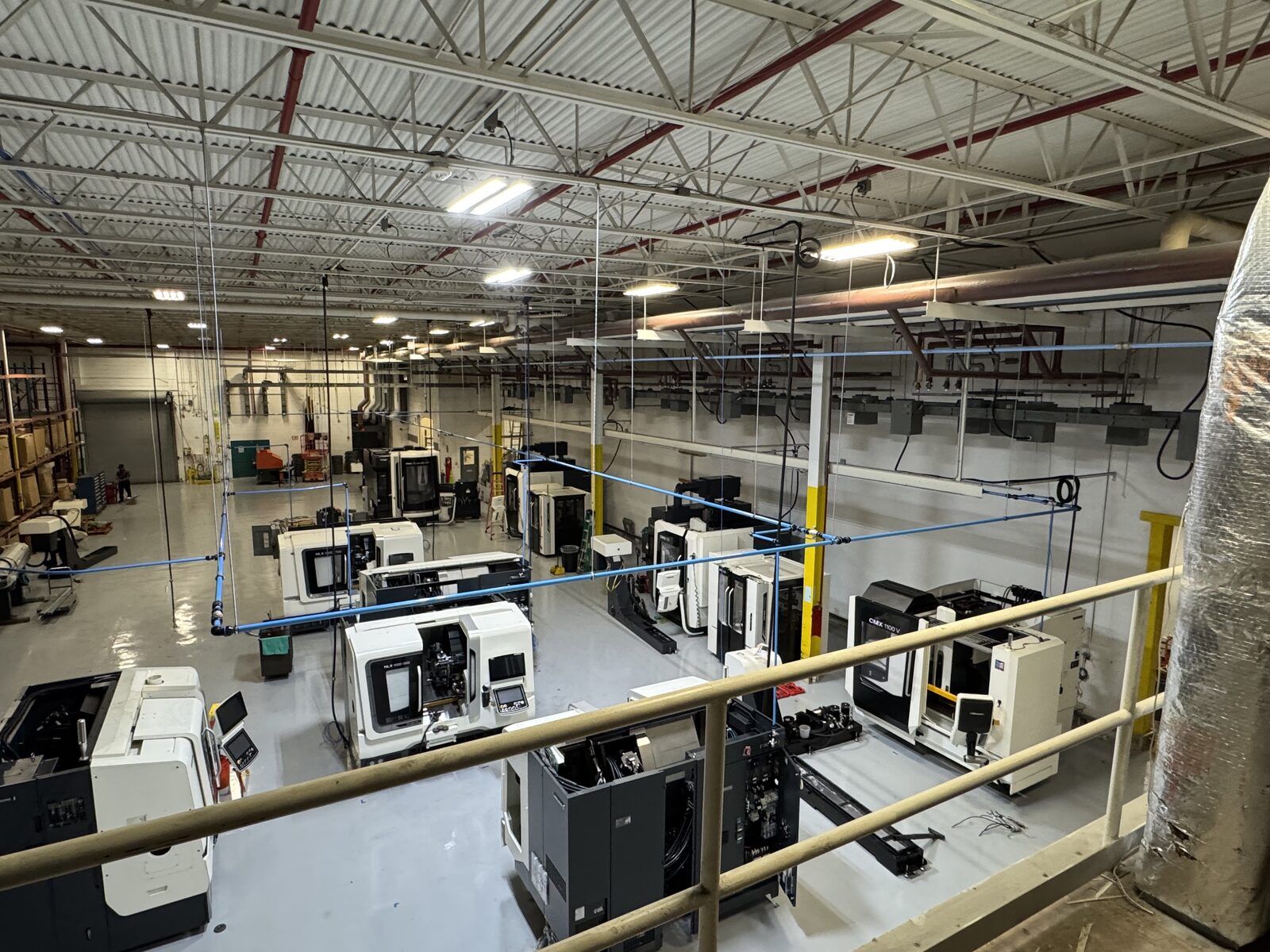 Overhead aluminum compressed air line piping installed above CNC machines in a Tampa Bay machine shop