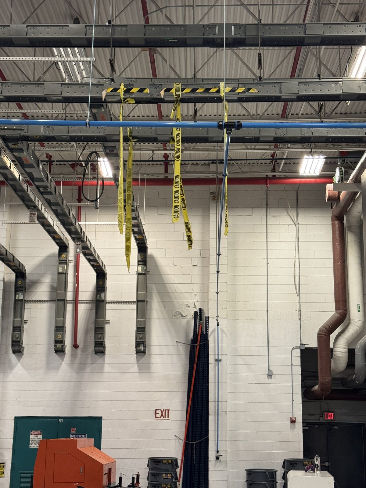Compressed air piping main and vertical drop leg routed down a machine shop wall - Advance Air Compressor Tampa FL